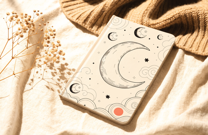Personalized keepsake baby book with a celestial moon cover resting on soft linen, by Clayit.