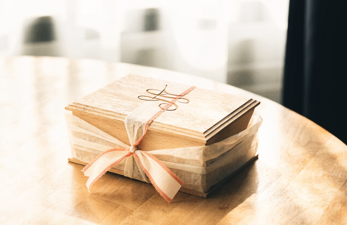 Personalized engraved wooden keepsake gift box tied with a coral-edged ribbon, by Clayit.